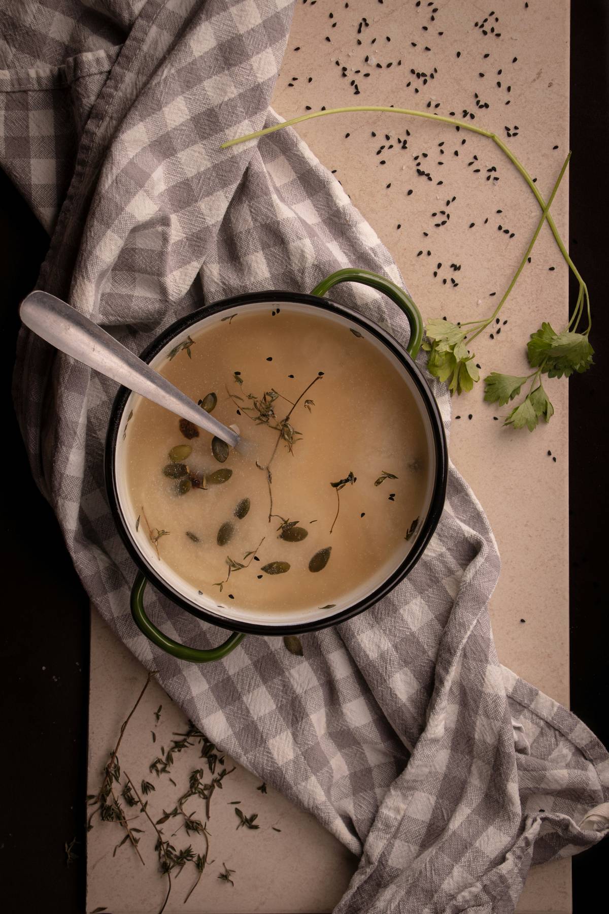 A pot of warm soup on a linen cloth, the kind of food that supports recovery after birth.