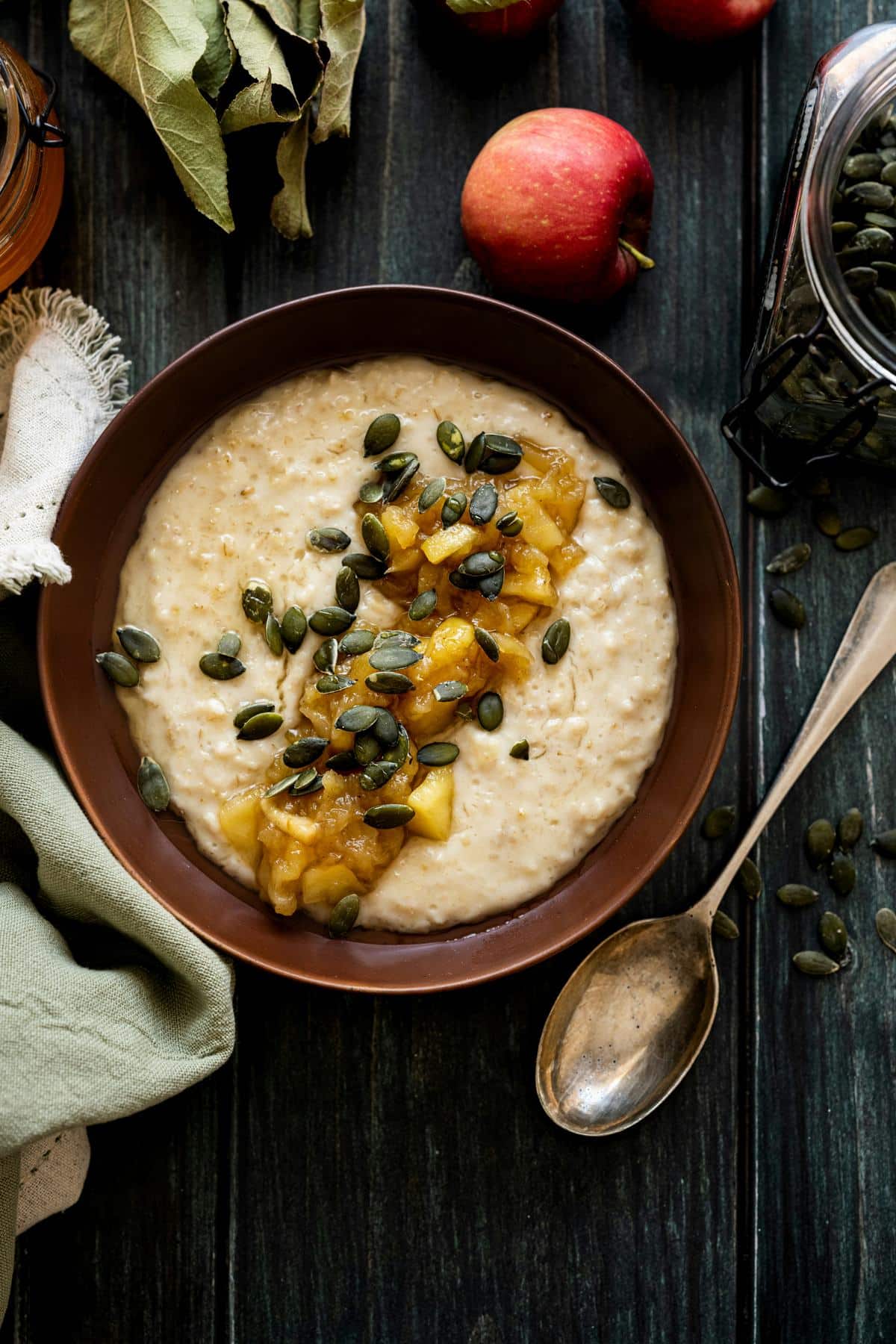 A bowl of porridge topped with pumpkin seeds and mango.