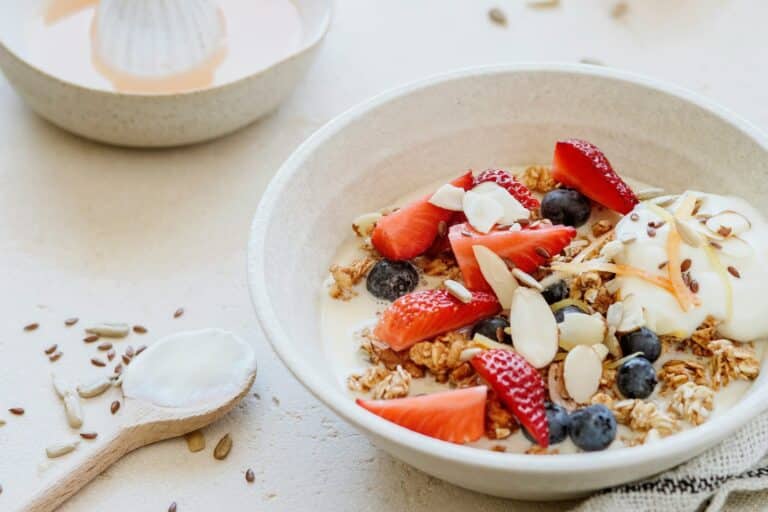 A bowl of oats topped with seeds and fresh fruit.