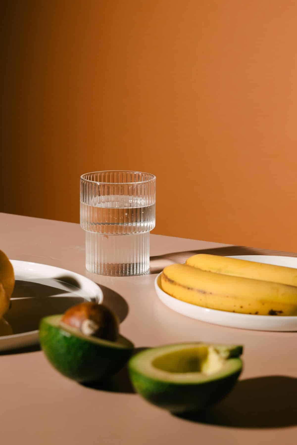 Banana, avocado and a glass of water, simple foods for steady blood sugar.