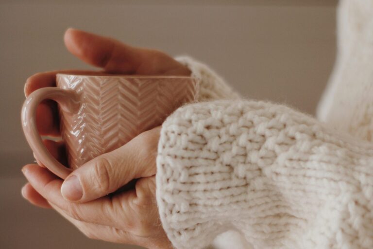 A woman's hands gently cradling a warm cup, evoking quiet hope.