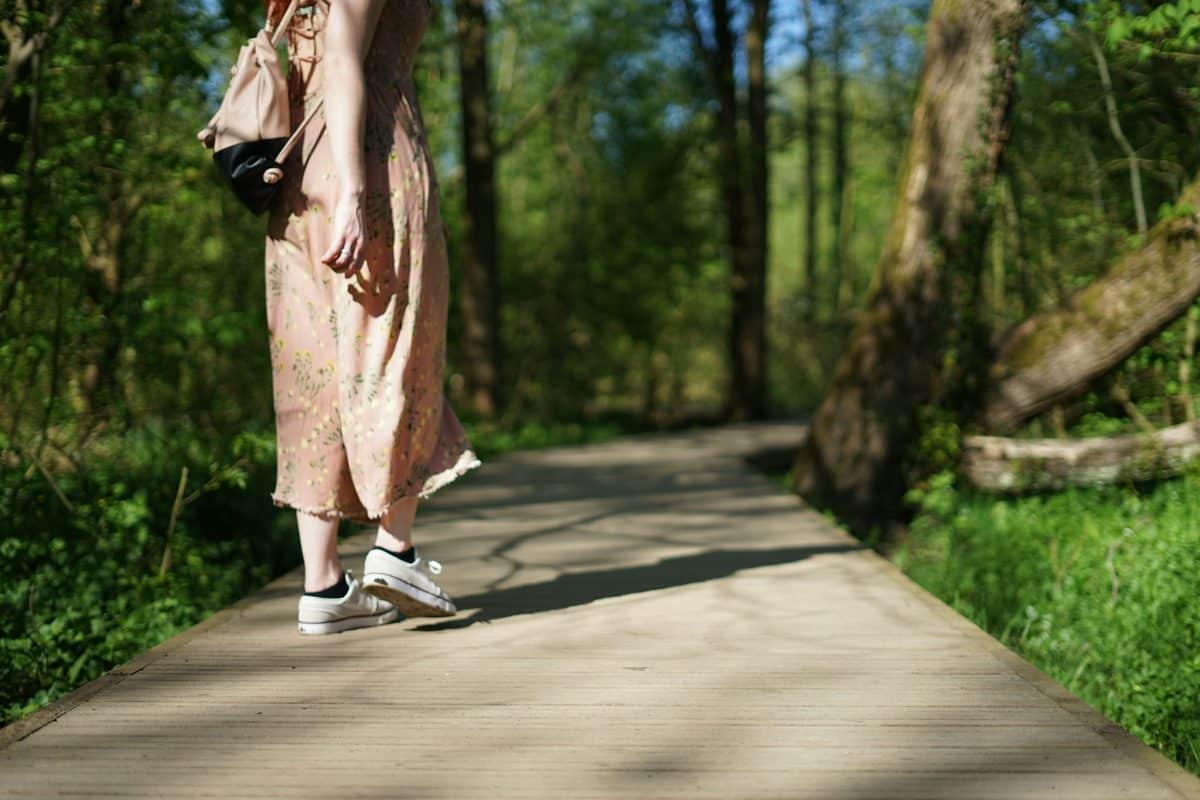A woman walking gently along a woodland path.