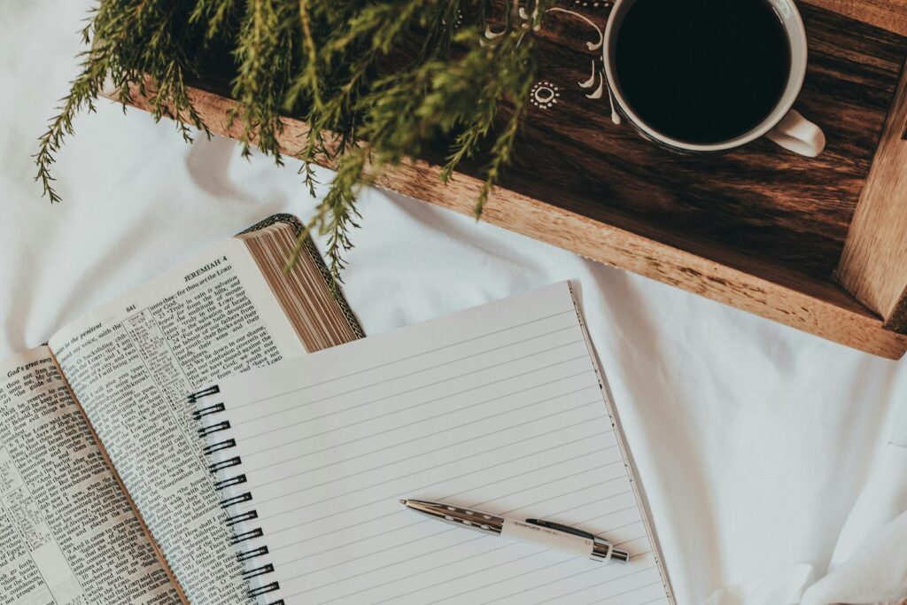 A journal, pen and coffee on a tray, for tracking your cycle.