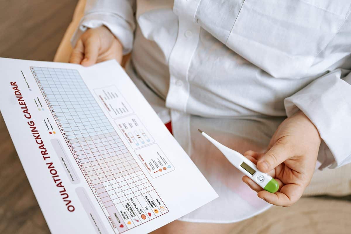 A woman filling in an ovulation tracking calendar.