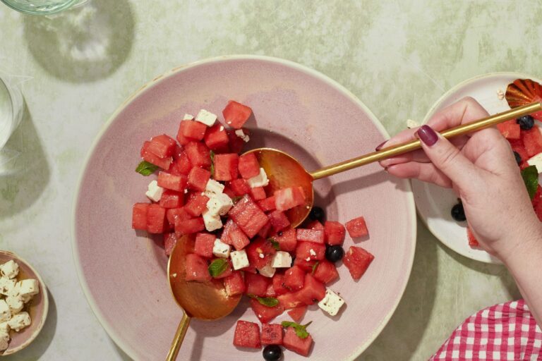 A plate of fresh watermelon and feta being served.