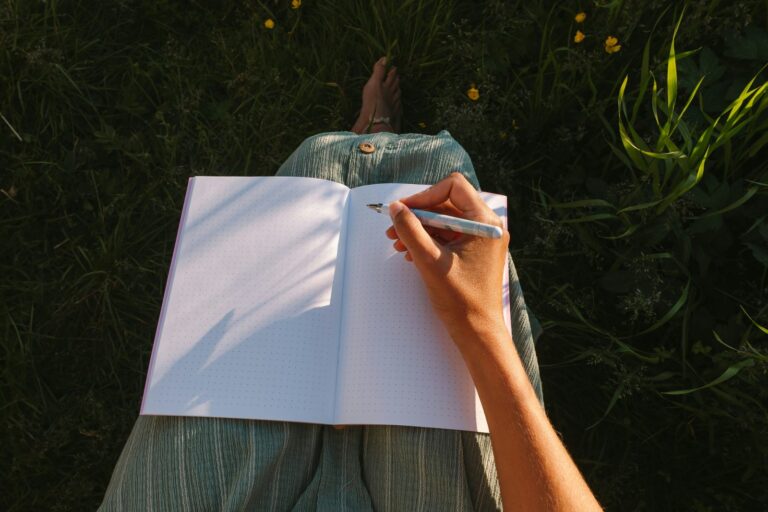 A woman sitting quietly with a journal and a cup of tea.